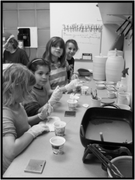 A group of Girl Scouts glazing their own work